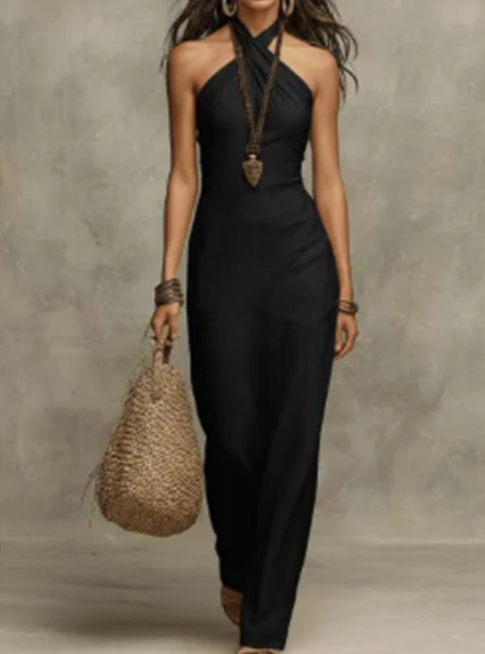 Woman in a black dress holding a woven bag against a neutral background