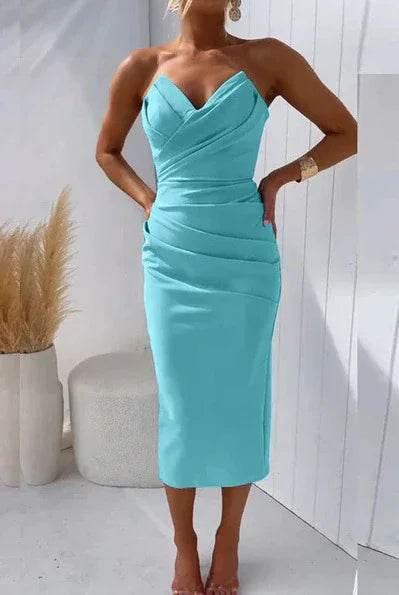 Woman wearing a fitted light blue midi dress with straps, in a minimal modern setting
