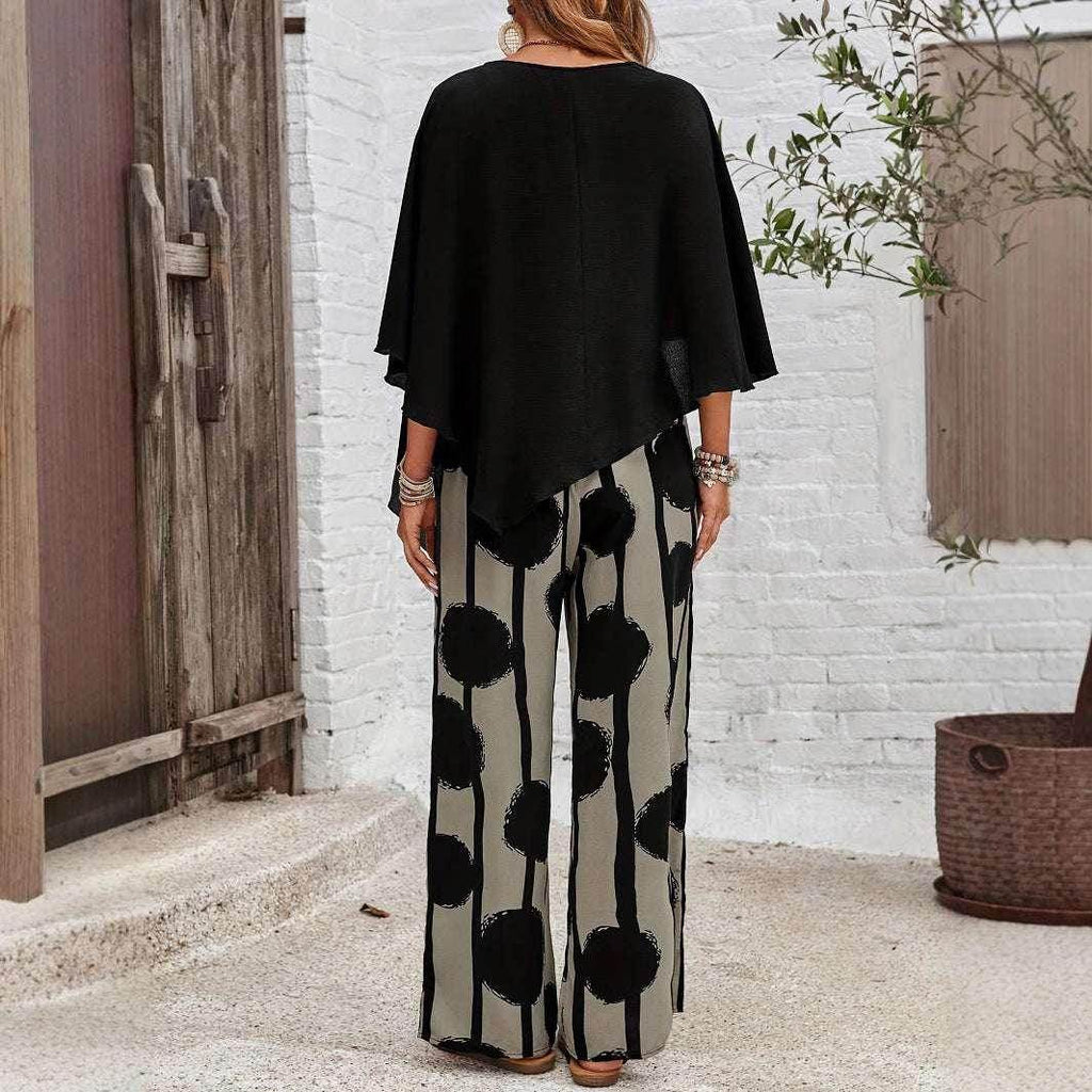 Woman wearing black poncho top and wide-leg polka dot pants, outdoor setting