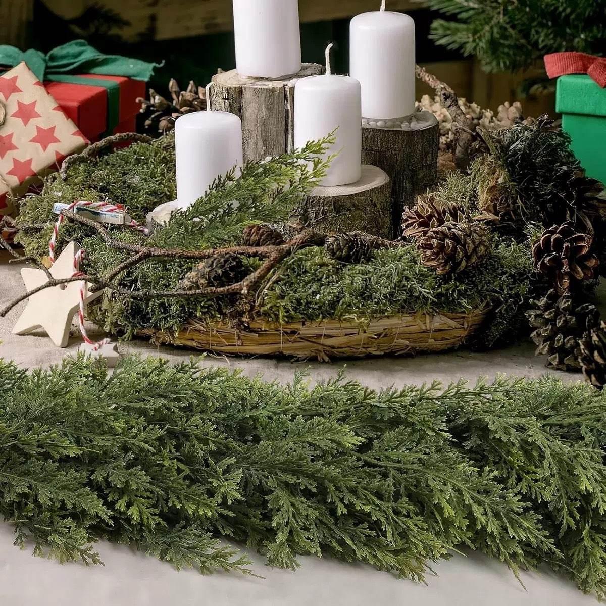 Festive Christmas centerpiece with white candles, pinecones, greenery, and wrapped gifts