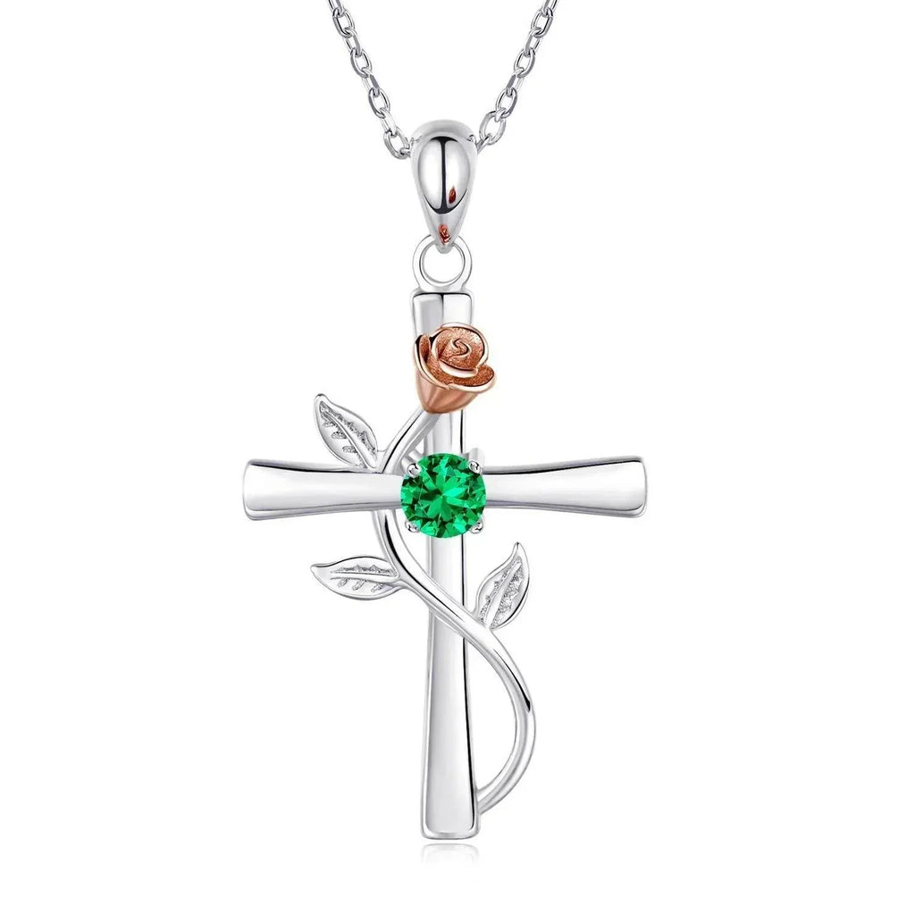 Silver cross pendant necklace with rose gold flower, green gemstone, and leaf accents