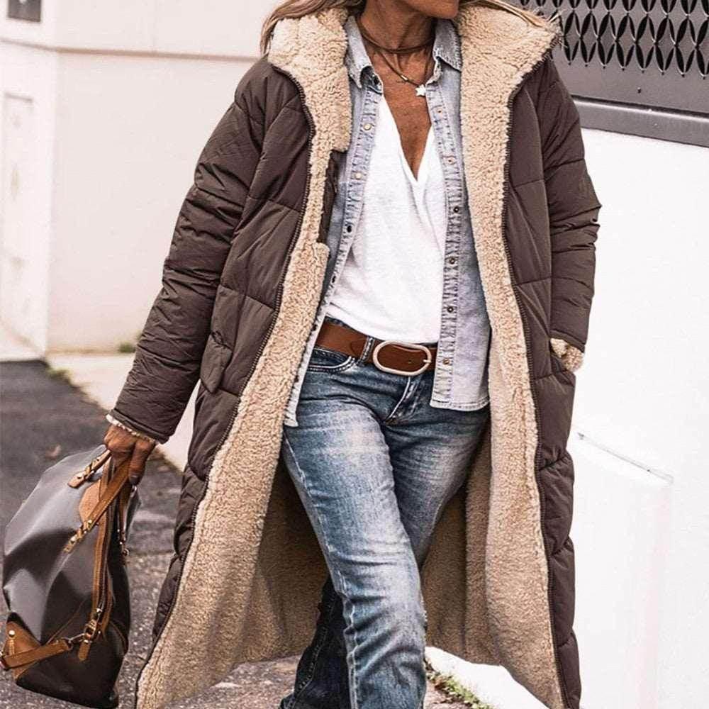 Woman in long brown sherpa-lined puffer coat, denim shirt, white tee, and jeans outdoors