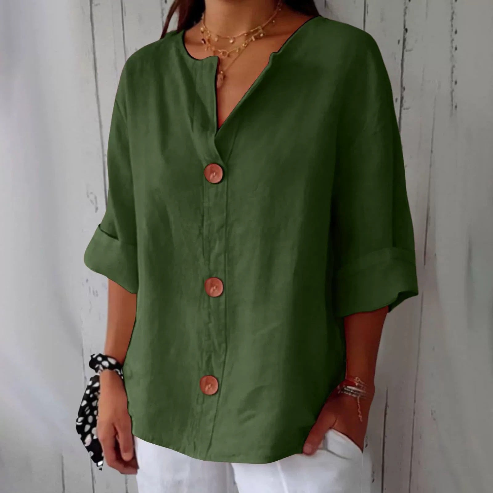 Person wearing a green button-up shirt with a white background