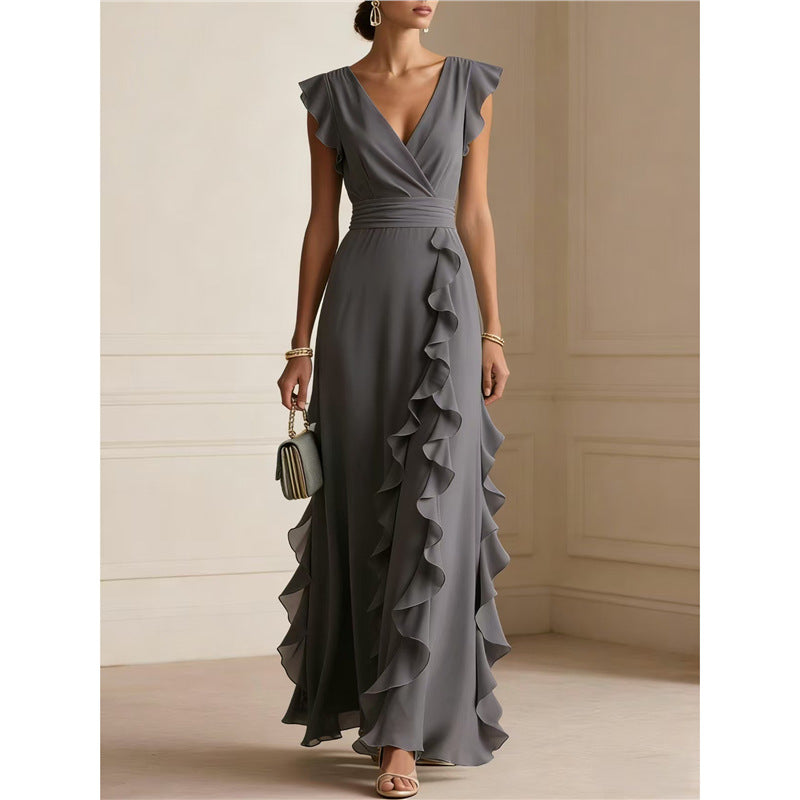 Woman wearing a gray ruffled gown in an elegant room.