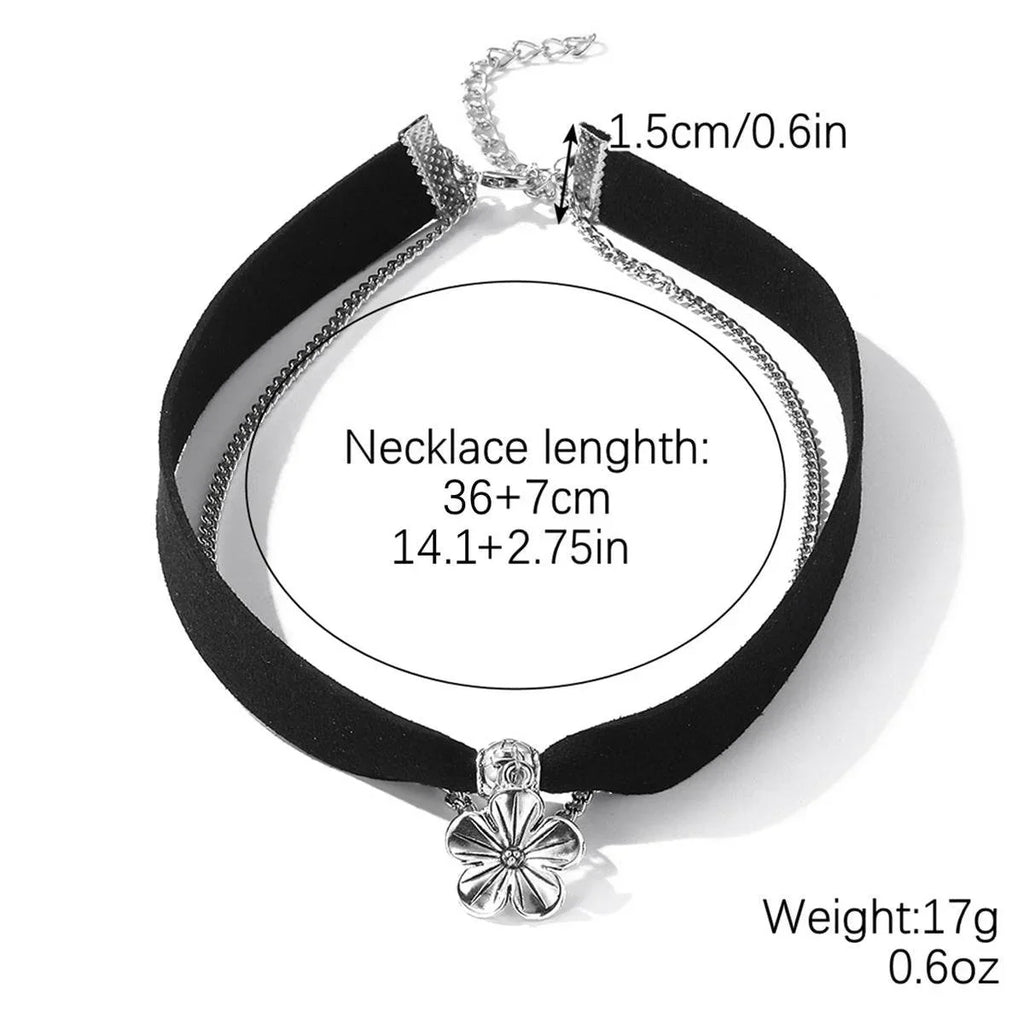 Black velvet choker necklace with silver flower pendant, chain extender, and size measurements