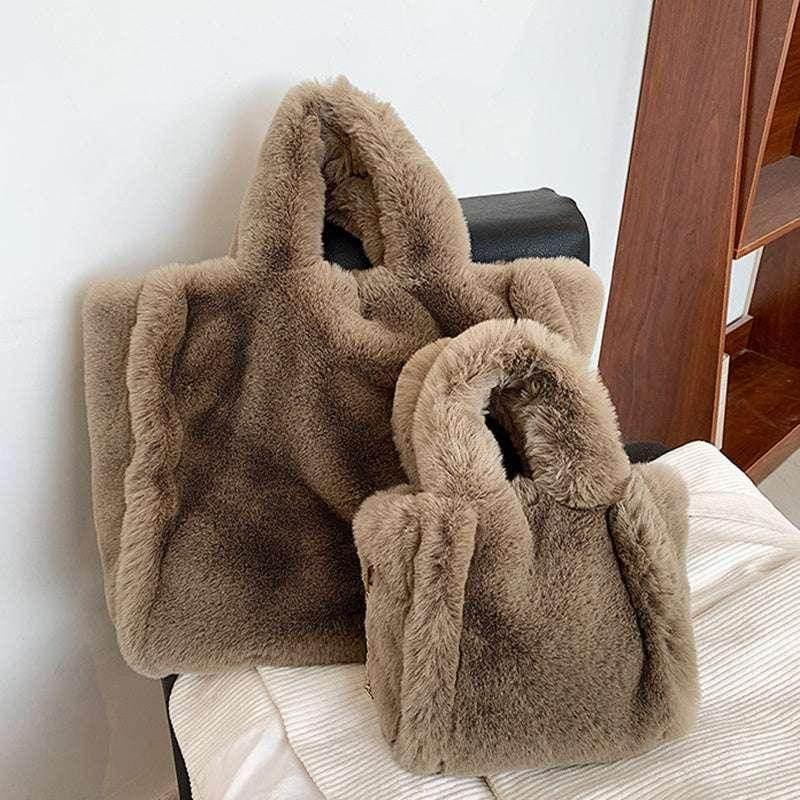 Two plush faux fur tote bags in light brown, displayed on a chair indoors.