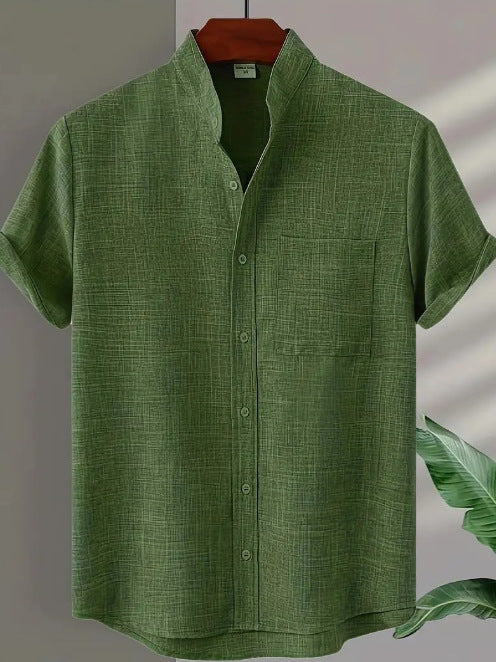 Green short-sleeve shirt on a hanger with a leafy branch in the corner