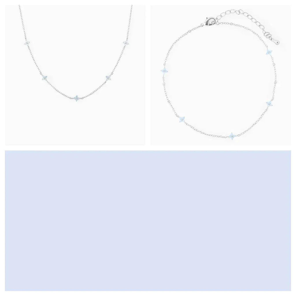 Delicate silver star necklace and bracelet jewelry set on a white background