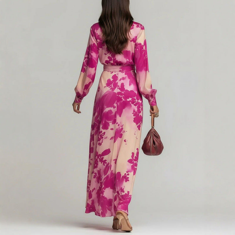 Woman wearing a pink floral dress holding a handbag against a plain background