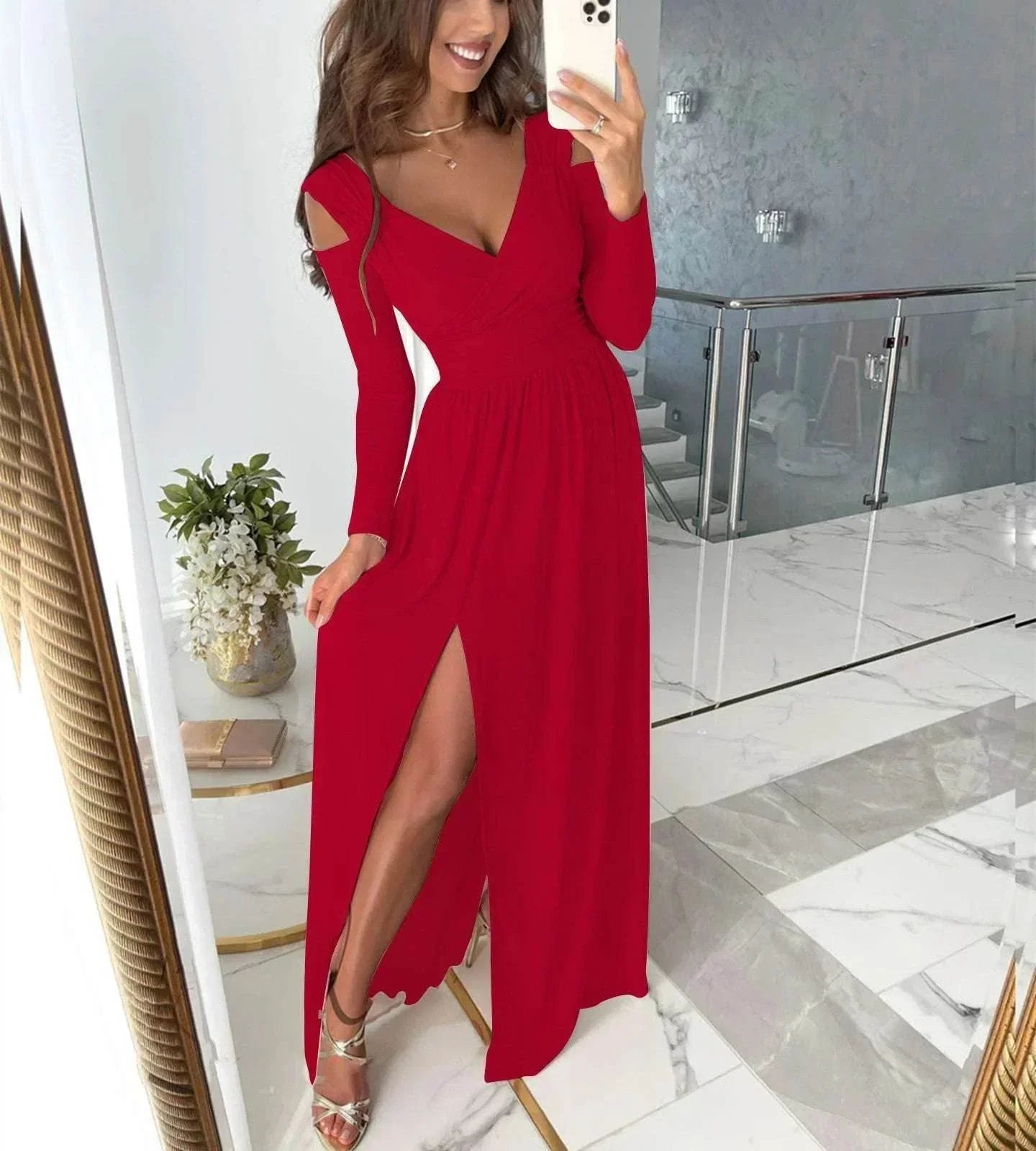 Woman in long red evening dress with thigh-high slit, posing indoors with marble floors