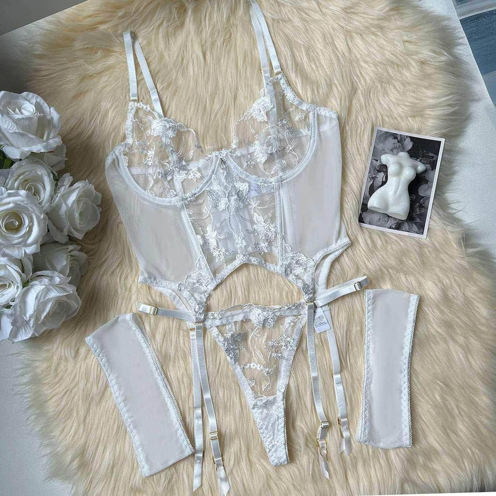 White lace lingerie set with floral embroidery, garter straps, and matching accessories on faux fur