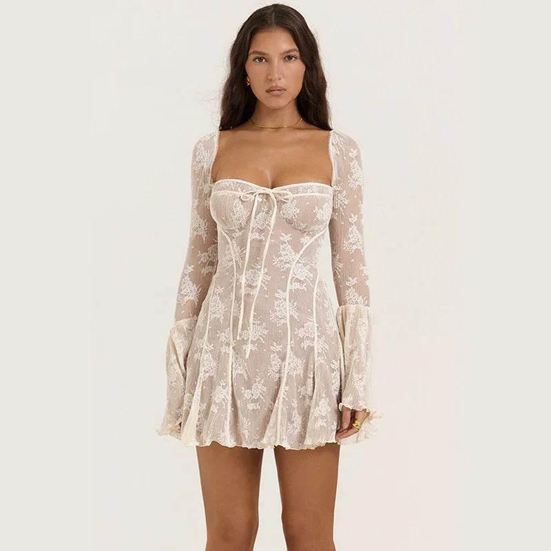 Woman wearing sheer white lace mini dress with long sleeves and floral pattern