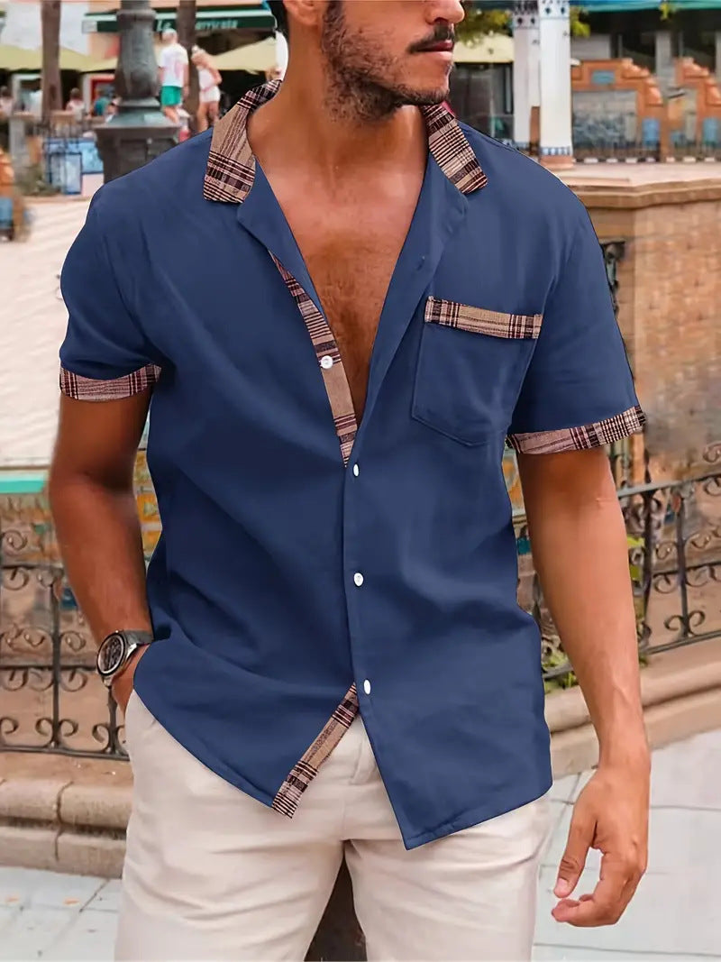 Man wearing a blue shirt with plaid accents in an outdoor setting