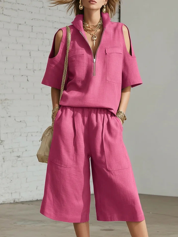 Woman wearing a pink outfit with a white brick wall background