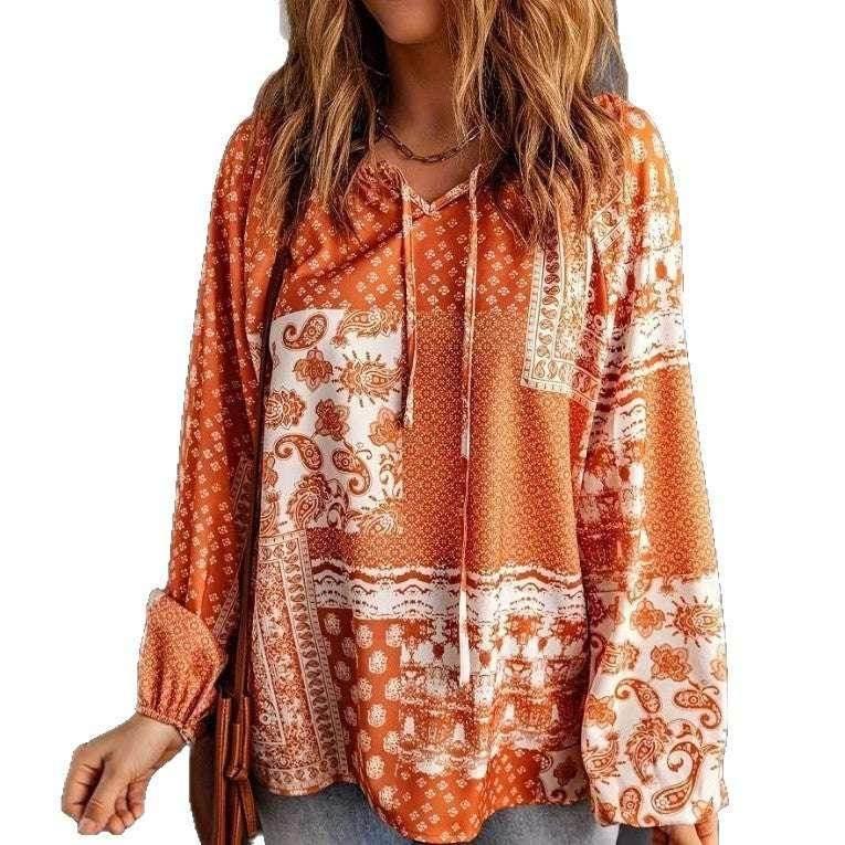 Woman in orange paisley print boho blouse with drawstring neckline and long sleeves