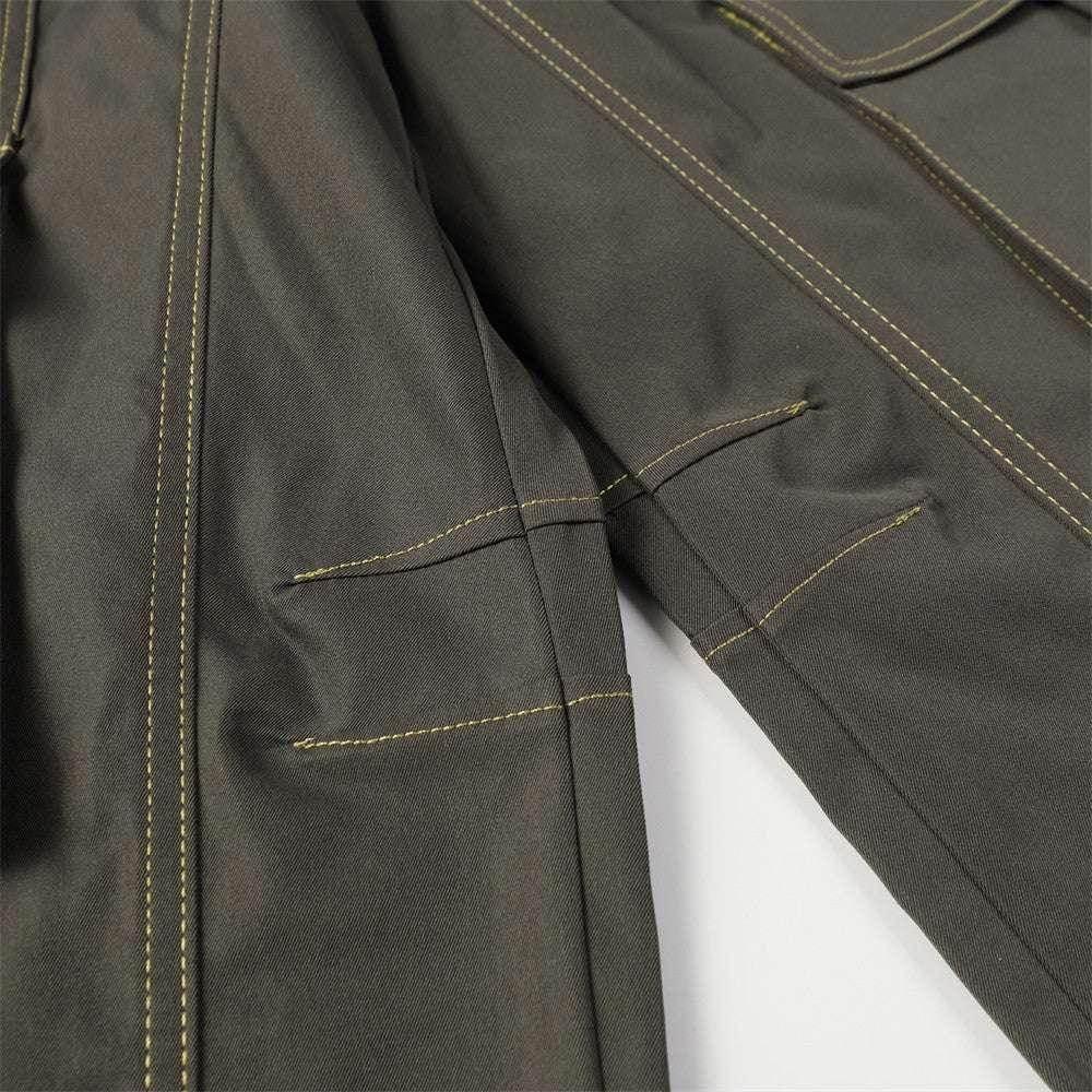 Close-up of khaki jacket sleeves with contrast stitching and flap pocket detail