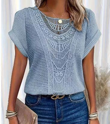 Woman wearing light blue crochet knit top with lace detail, paired with blue jeans and accessories.