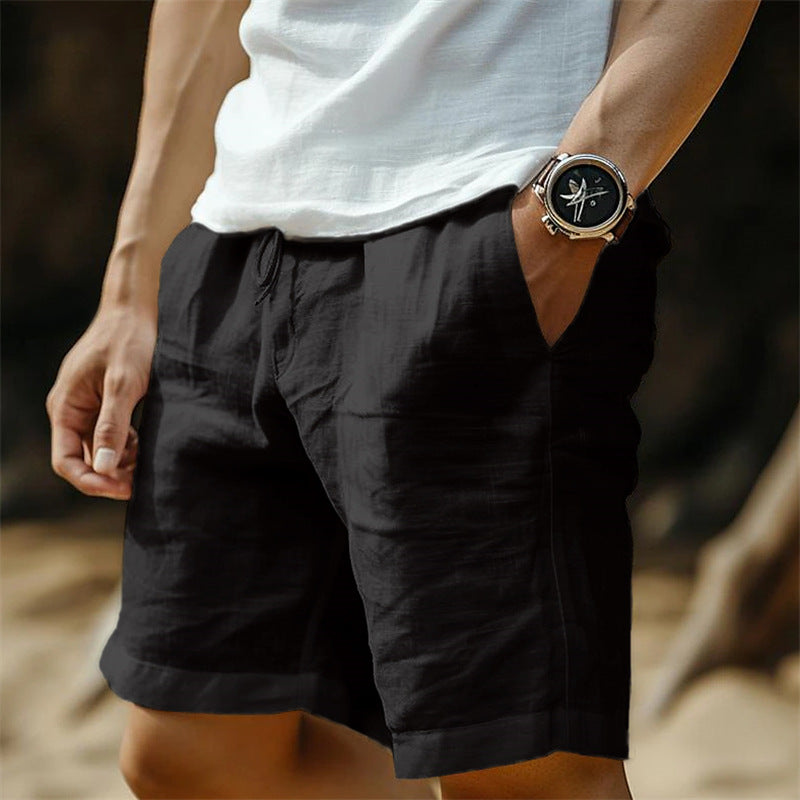 Person wearing black shorts and a white shirt with a watch on a blurred background