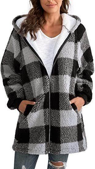 Woman wearing a black and white plaid sherpa fleece hooded jacket with pockets