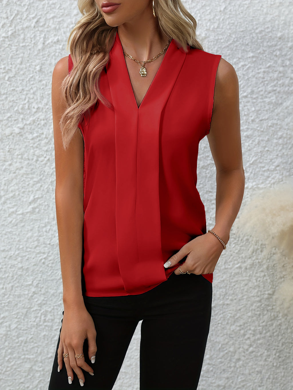 Woman wearing a red sleeveless top against a white background