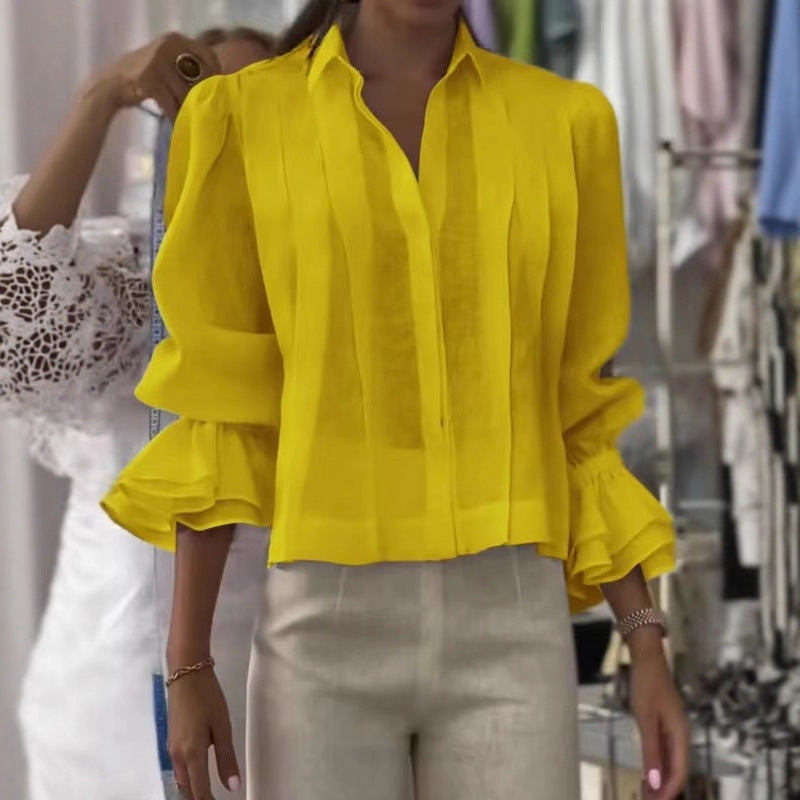 Person wearing a yellow blouse with ruffled sleeves in a clothing store.