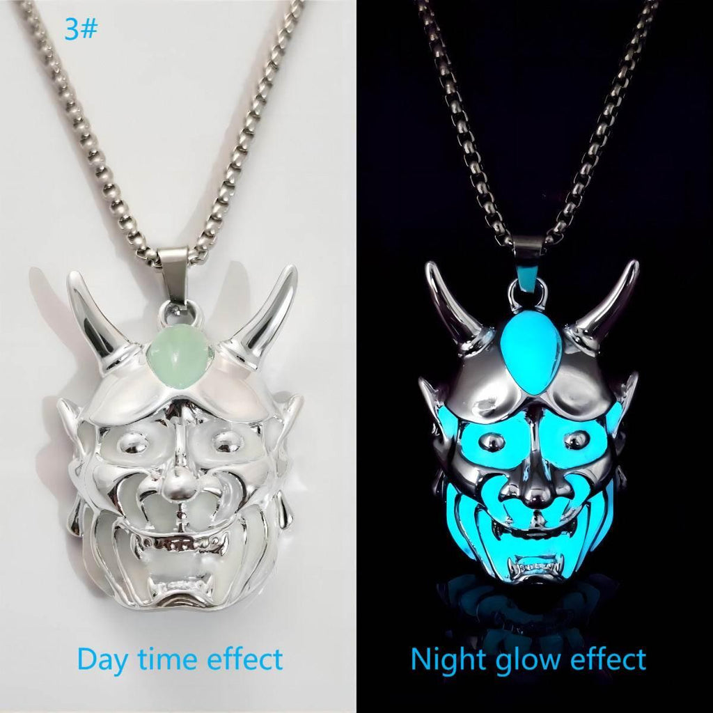 Silver demon mask pendant necklace with glow-in-the-dark blue accents, shown in day and night.