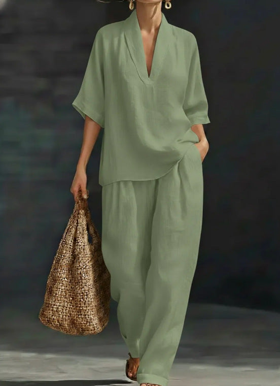 Person wearing a green outfit holding a woven bag against a dark background