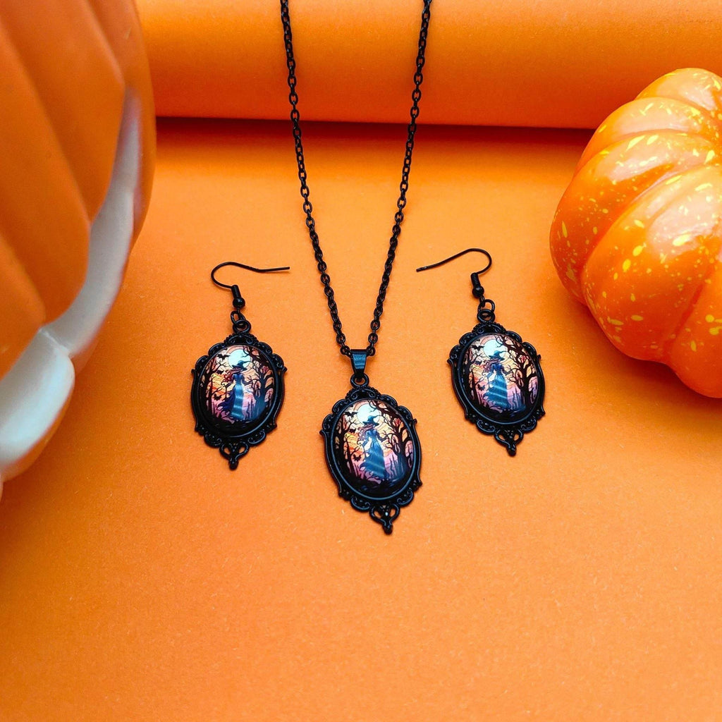Halloween-themed black cameo necklace and earrings set with haunted forest design, styled with pumpkins on orange background.