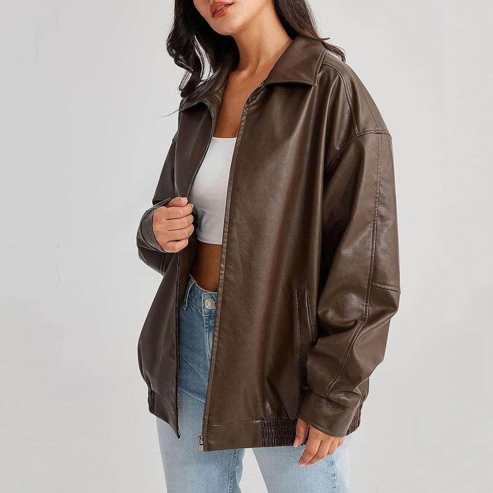 Woman wearing oversized brown faux leather jacket, white crop top, and light blue jeans