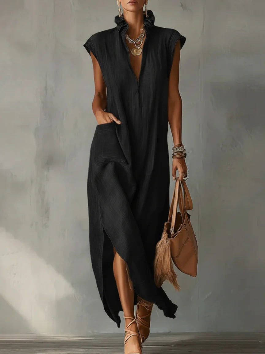 Woman wearing a black sleeveless dress with a plain background