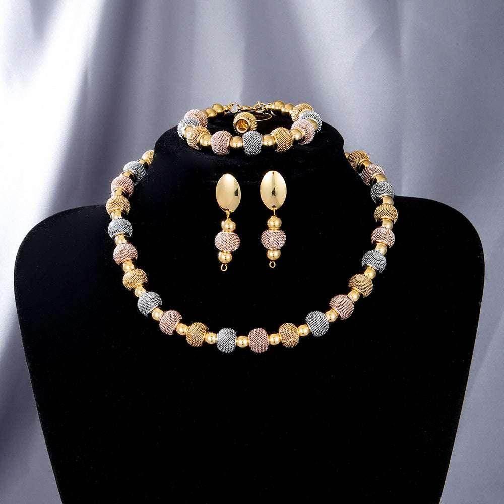 Elegant gold, silver, and rose beaded jewelry set with necklace, earrings, and bracelet on display.