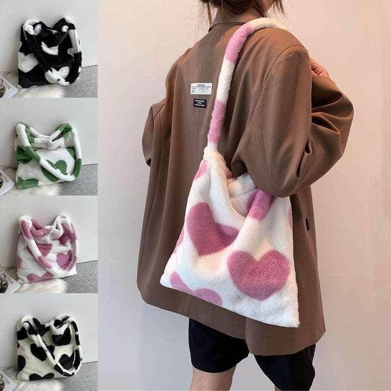 Woman wearing a fuzzy tote bag with pink hearts, available in various colors, trendy accessory.