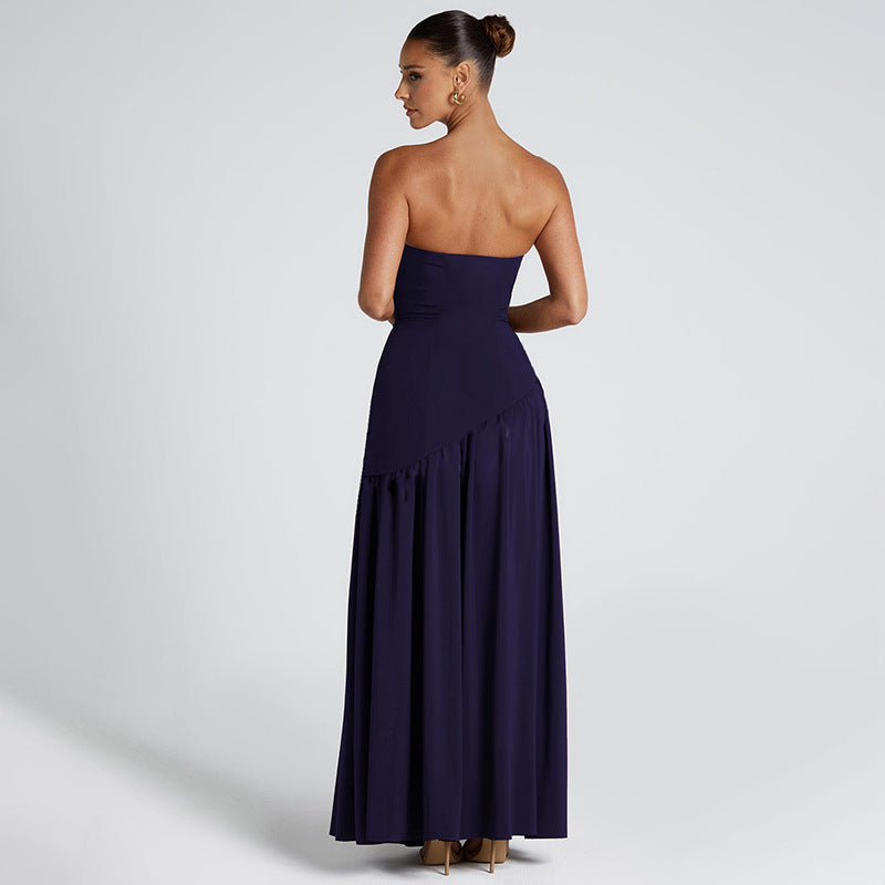 Woman wearing a strapless navy blue gown on a light gray background