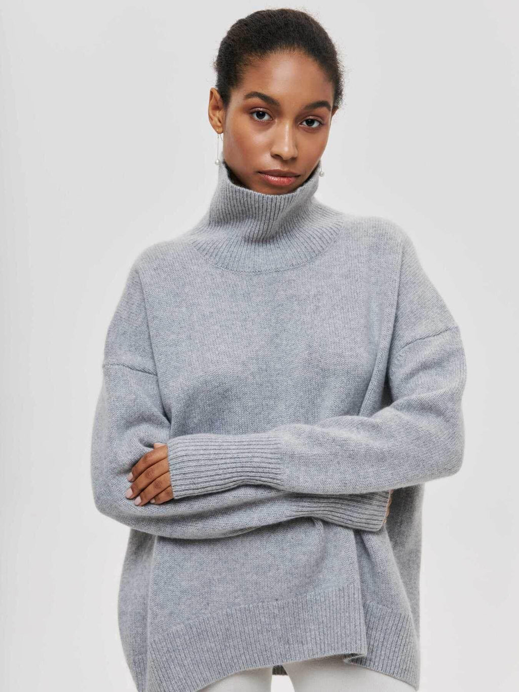 Woman wearing light grey turtleneck oversized sweater, cozy winter fashion style