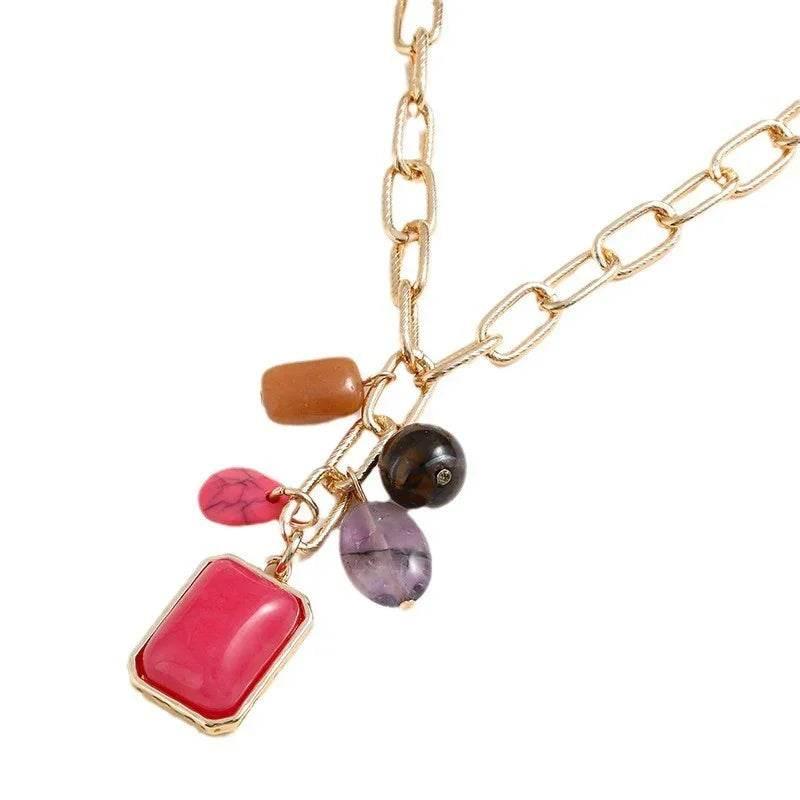 Gold chain necklace with colorful stone pendants, featuring pink, purple, brown and black charms.