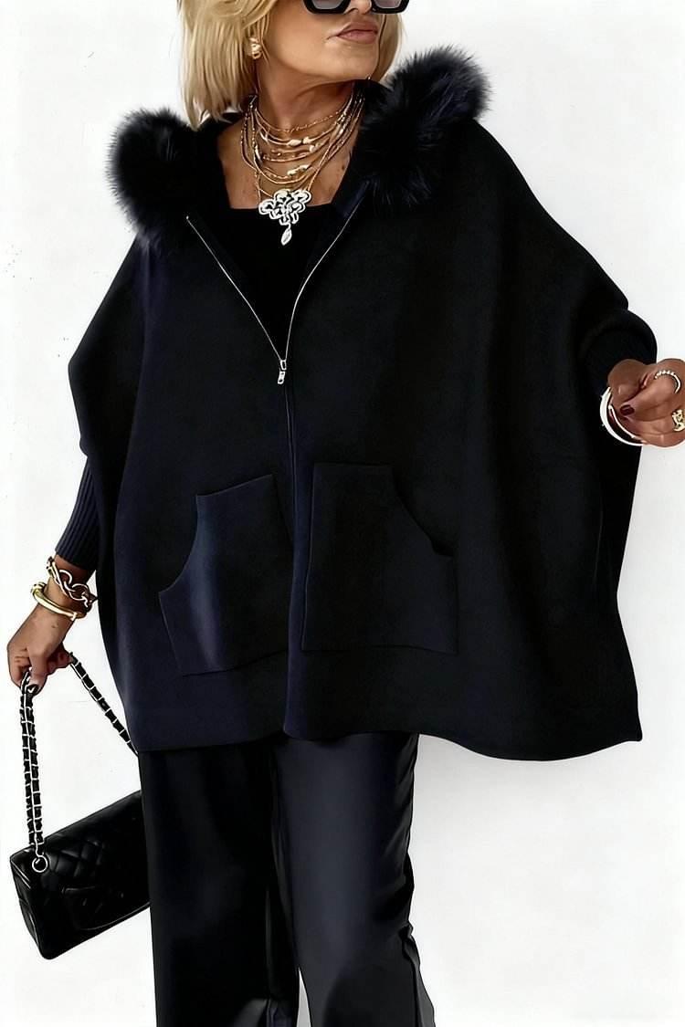 Woman in stylish black faux fur-trimmed cape, wide-leg pants, layered jewelry, and sunglasses