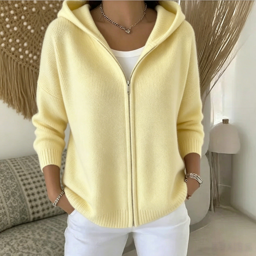Person wearing a yellow zip-up hoodie in a cozy indoor setting