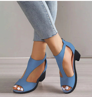 Blue high-heeled shoes worn with light blue jeans on a neutral background