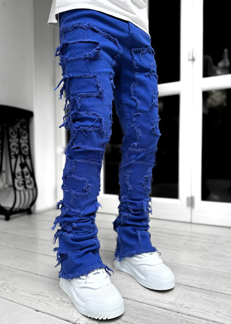 Blue ripped jeans worn by a person indoors with a blurred background