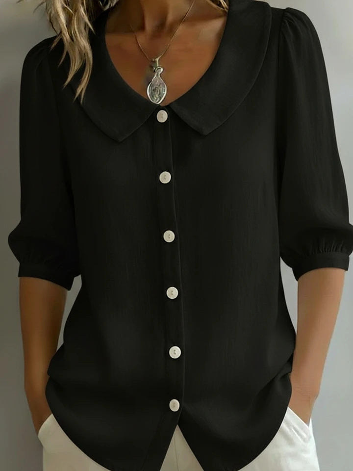 Black blouse with a collar and buttons on a neutral background
