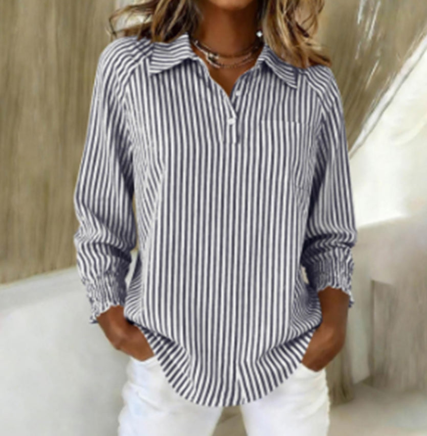 Woman wearing a blue and white striped shirt with a blurred background