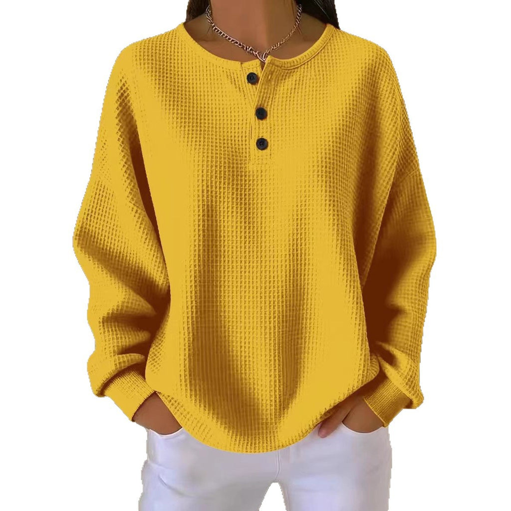 Yellow textured long-sleeve top with black buttons on a white background