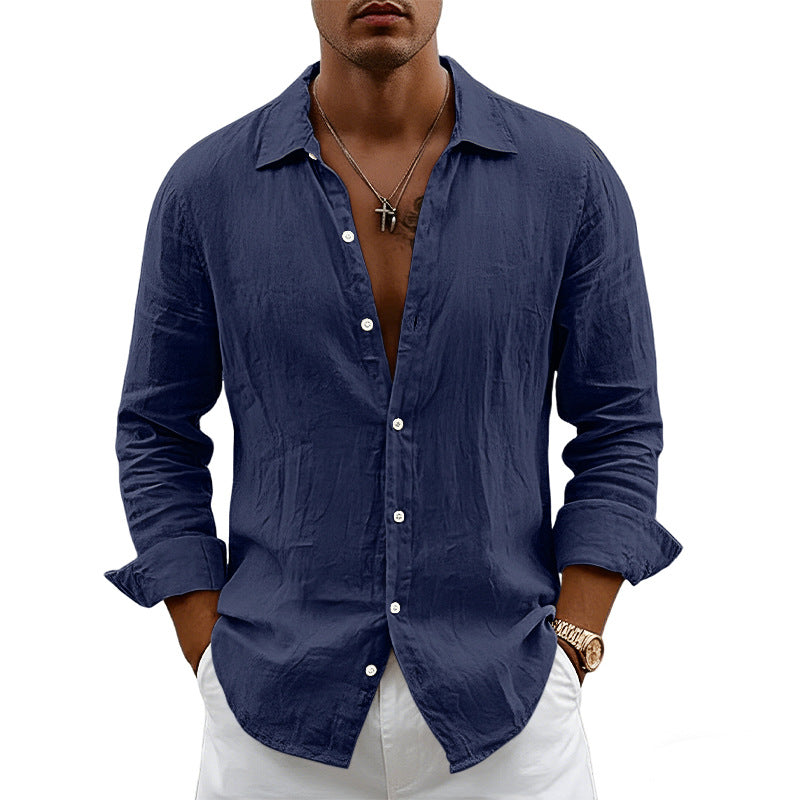 Man wearing a blue button-up shirt with rolled-up sleeves on a white background