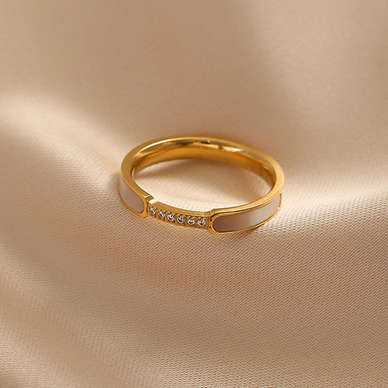 Gold ring with small diamonds on a beige fabric background