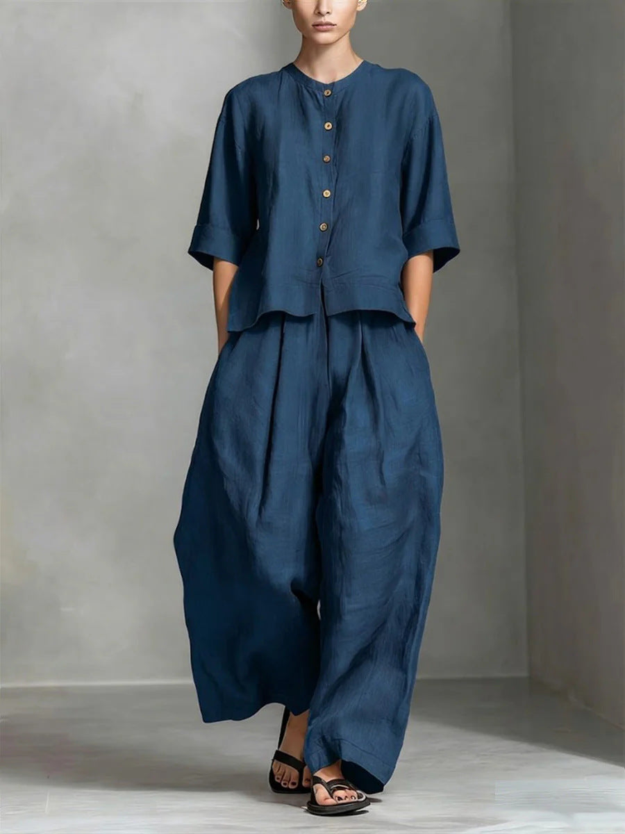 Person wearing a blue outfit with wide-leg pants against a gray background