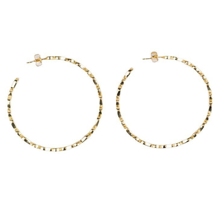 Gold hoop earrings with beaded detailing on a white background