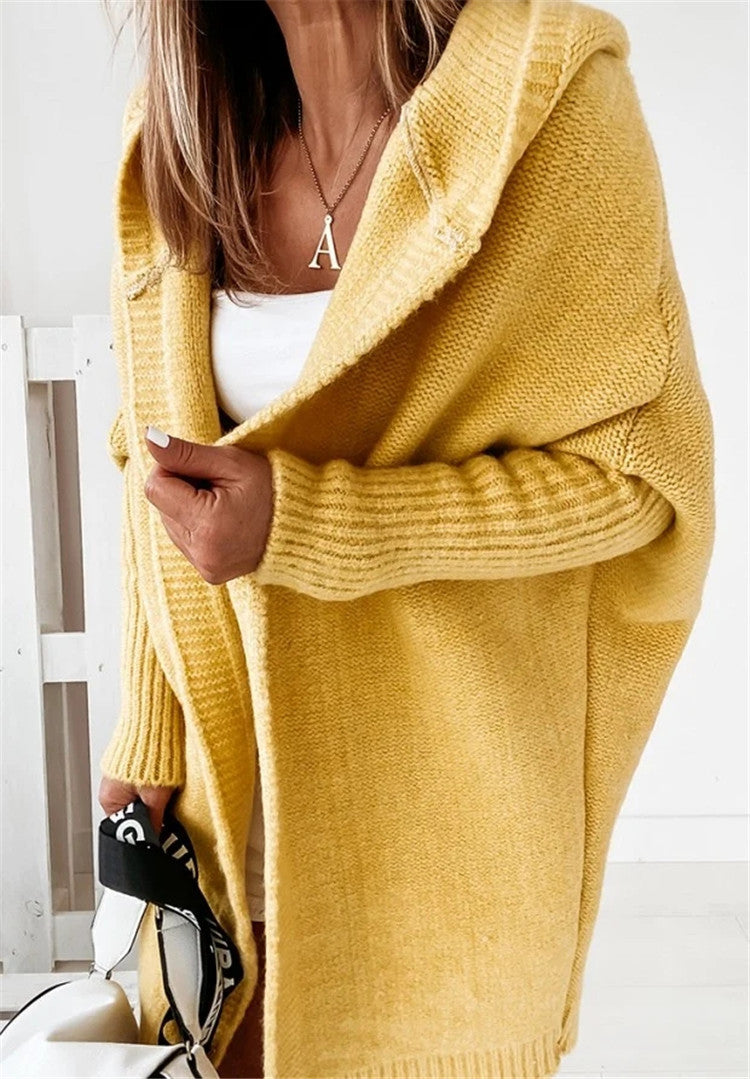 Person wearing a yellow cardigan with a white background