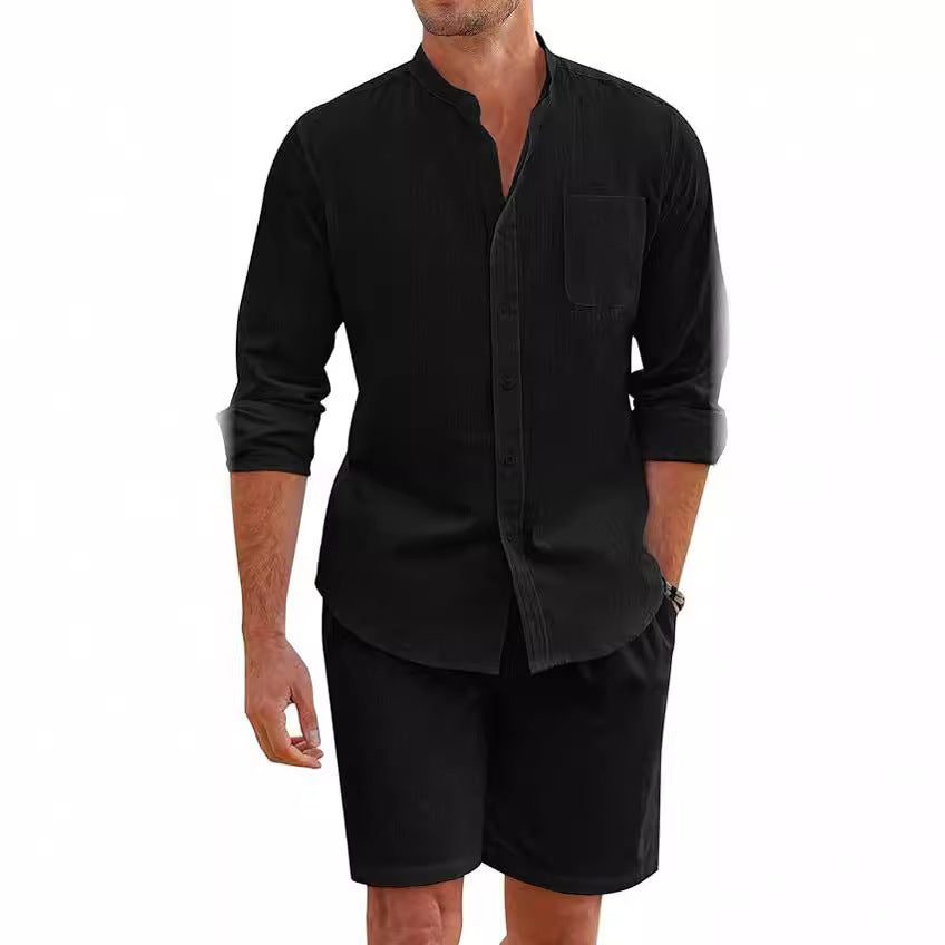 Man wearing a black long-sleeve shirt and black shorts on a white background