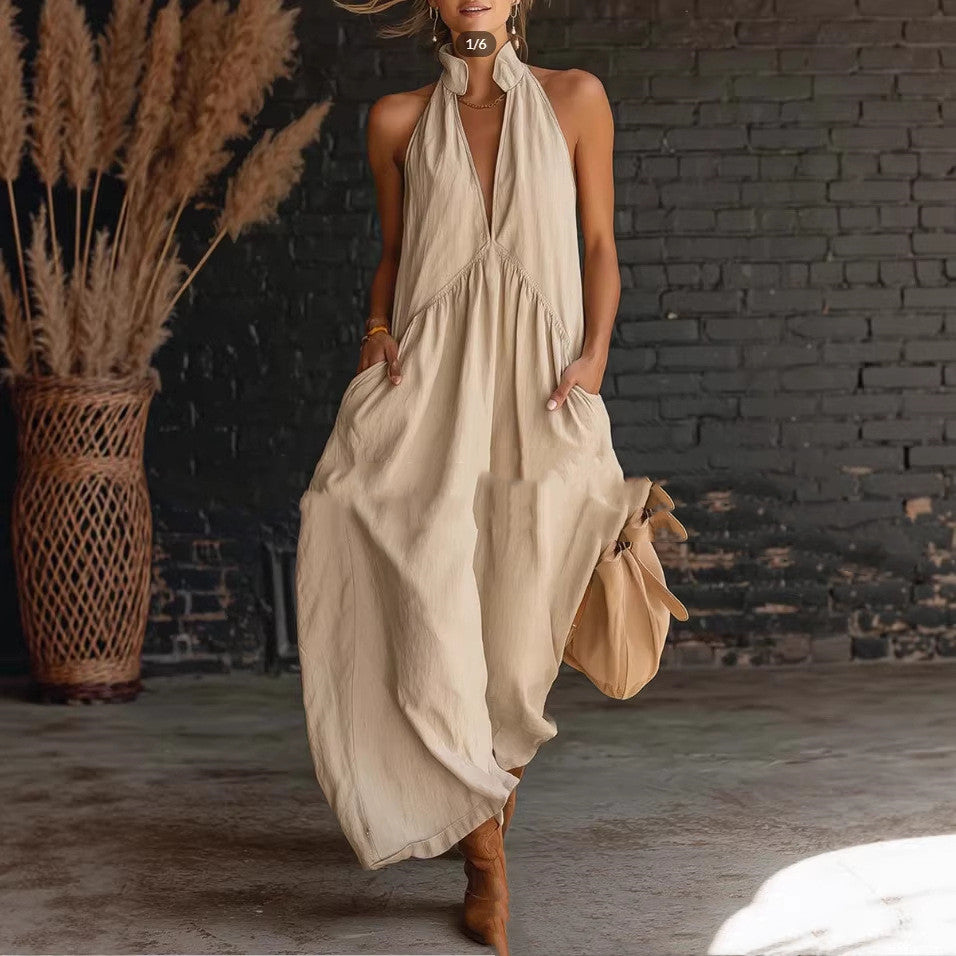 Woman wearing a beige halter neck dress with a brick wall background