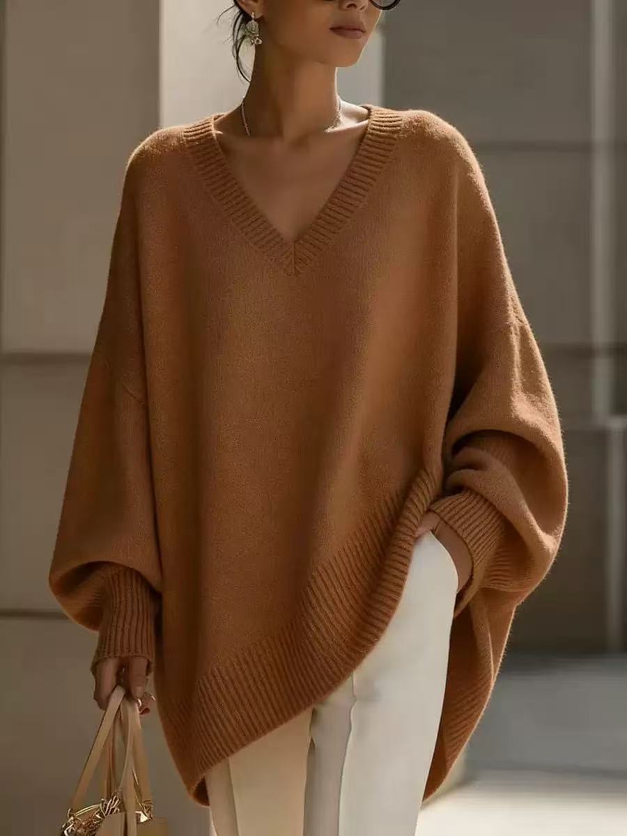 Woman wearing a brown poncho in an indoor setting